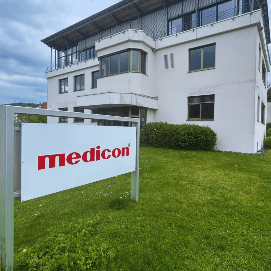 Technicum Medicon. ChatGPT: Das Gebäude auf dem Bild zeigt ein modernes Bürogebäude mit einem Schild davor, auf dem „medicon“ in roten Buchstaben steht.